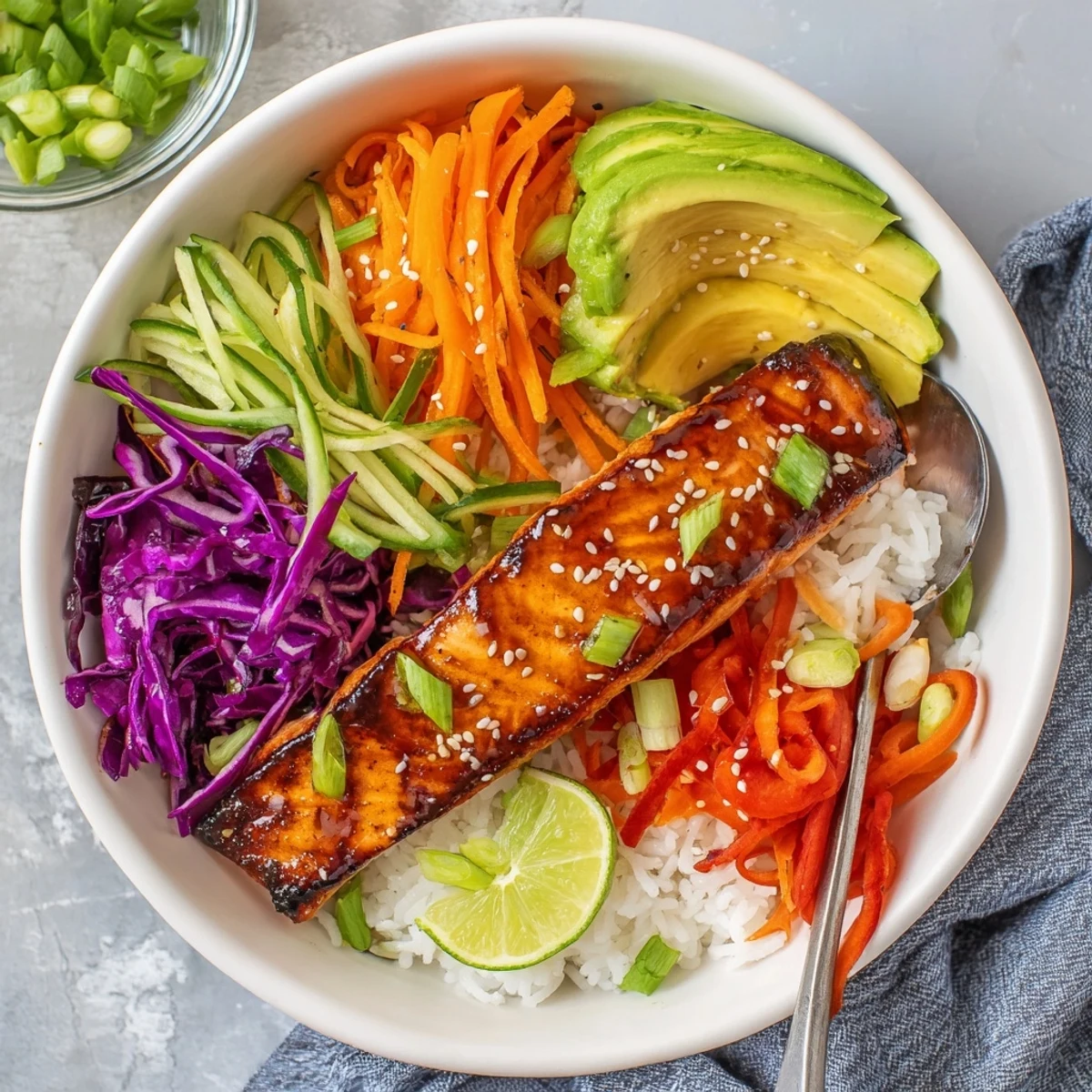 Glazed salmon drizzled in soy-maple sauce atop a colorful vegetable rice bowl.  