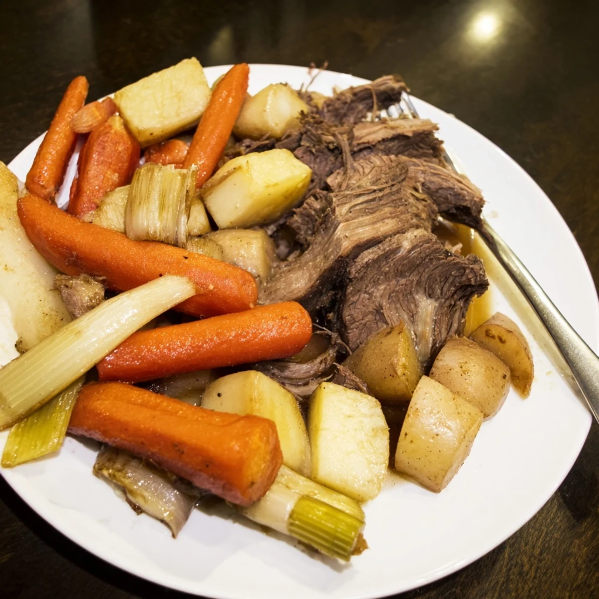 Fork-tender Sunday Pot Roast in a Dutch oven, surrounded by perfectly browned roasted carrots, onions, and potatoes.