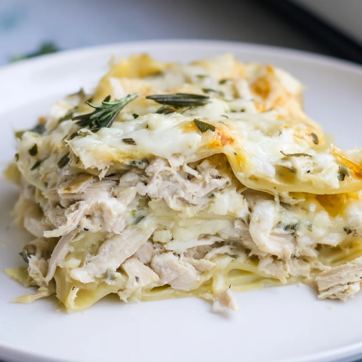 A steaming Rosemary Chicken Lasagna, layered with creamy béchamel, baked to golden perfection.