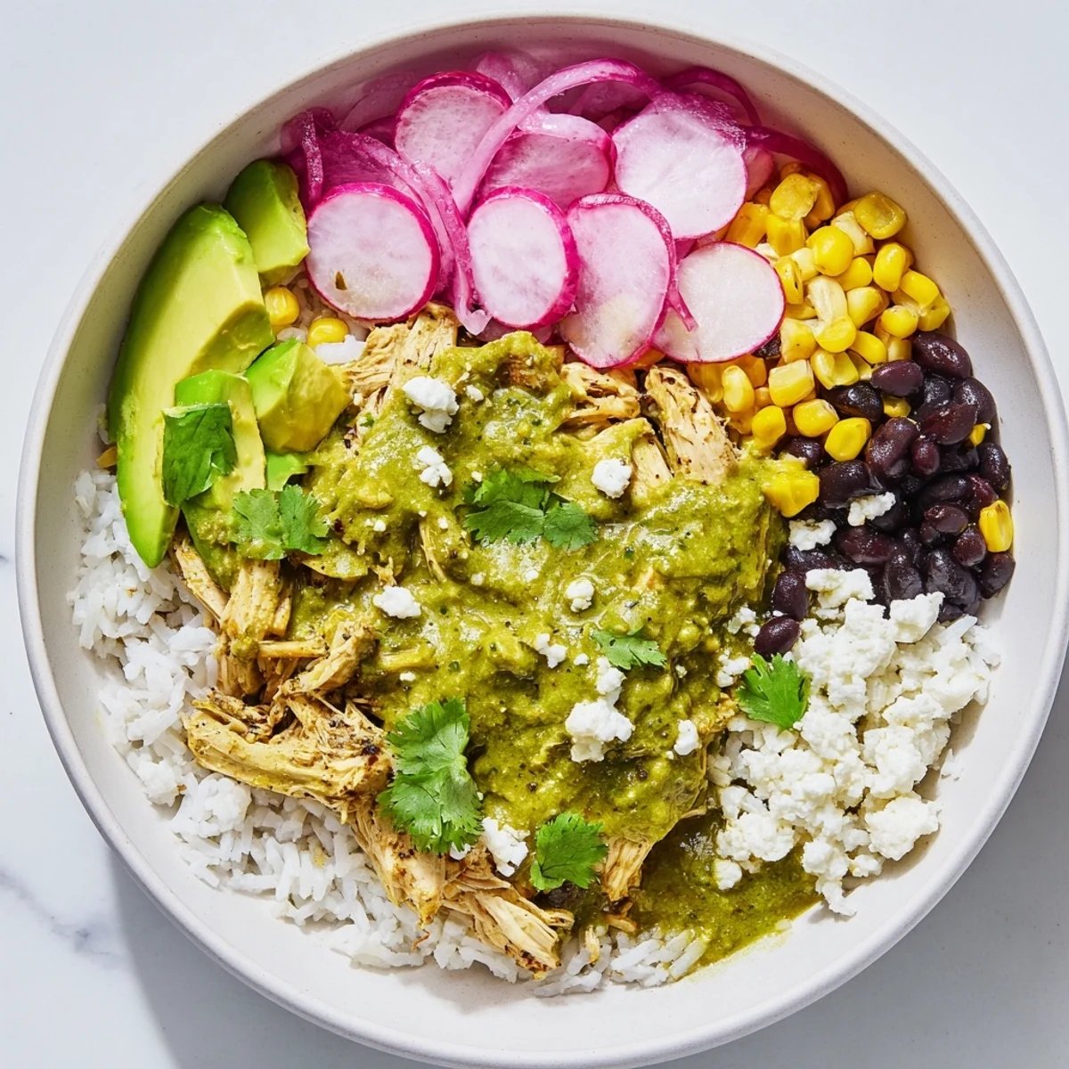 A close-up shot of the delicious Green Enchiladas Rice Bowl with avocado and cheese, ready to eat.
