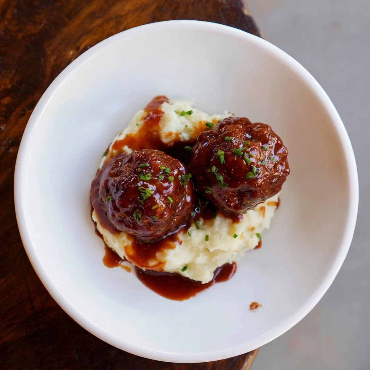 Savory BBQ Meatballs with a glistening sauce, served alongside smooth, buttery mashed potatoes.