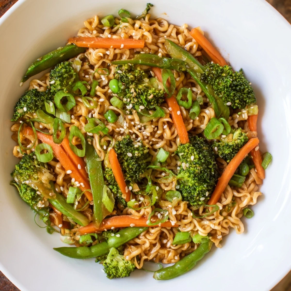 Steaming bowl of Ramen Noodle Stir-Fry Remix, colorful vegetables glistening from a savory sauce.