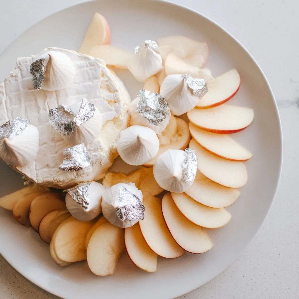Elegant cheese board, "The Pearly Gates," with creamy brie, sliced peaches, and crisp meringue ready to serve.