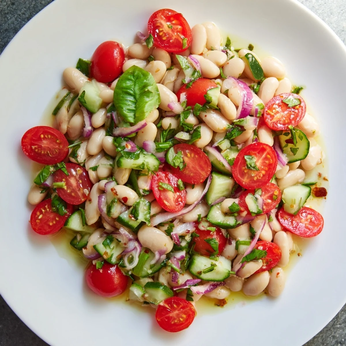 A close-up of creamy white bean salad showcasing fresh herbs and a bright, flavorful dressing.
