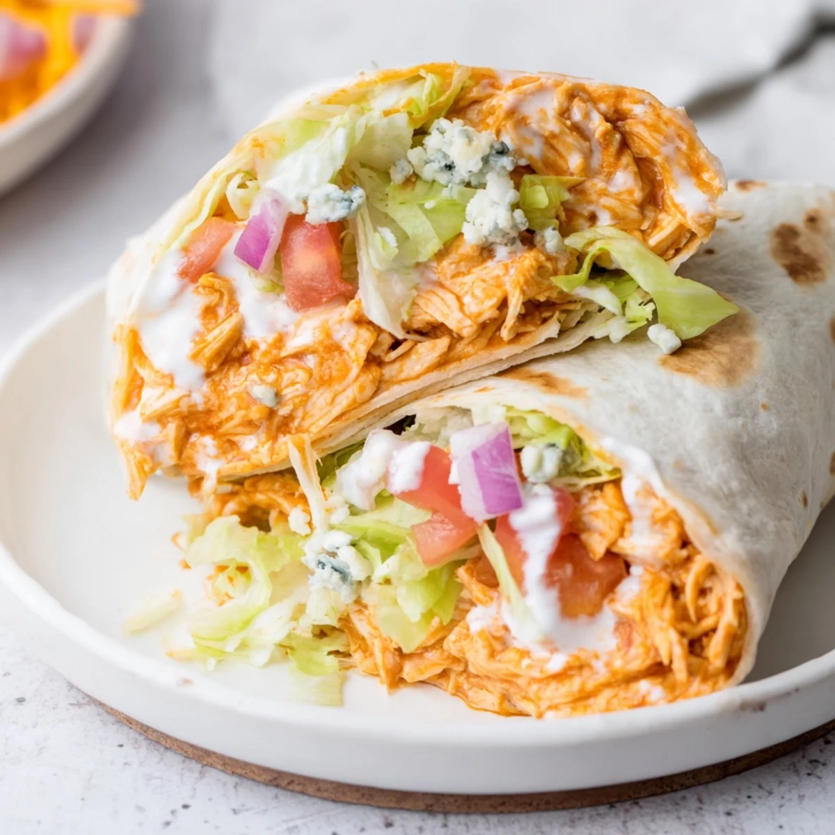 Golden-brown Buffalo Chicken Wrap, filled with savory chicken, vegetables, and creamy dressings.
