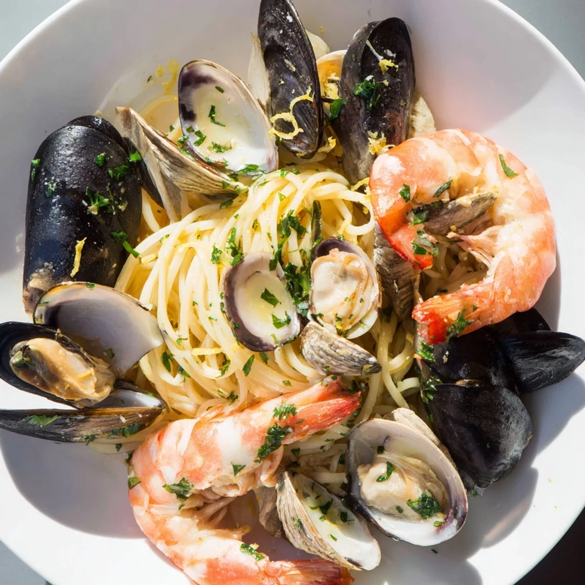 Linguine with seafood, a flavorful dish with plump shrimp, clams, and mussels in a garlic sauce.