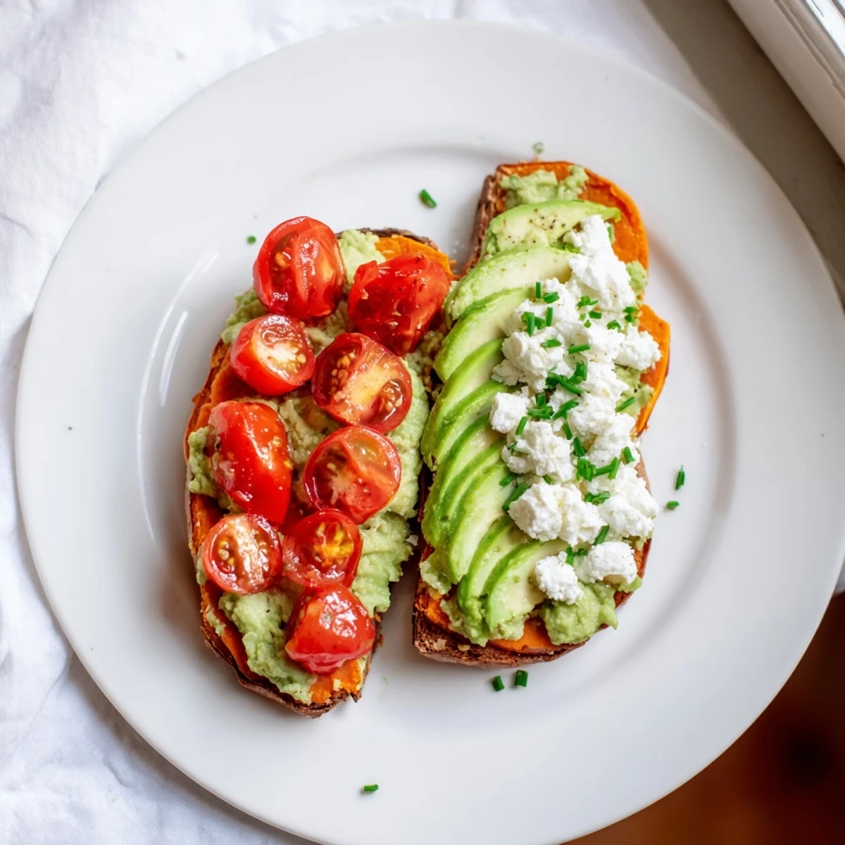 Warm sweet potato toast slices spread with peanut butter and sliced bananas, sprinkled with crunchy granola for a satisfying snack.  
