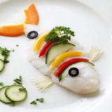 Glistening, baked Light Fish-Shaped Meal, showcasing a white fish fillet designed with cucumber fin detail.