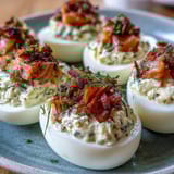 Smoked salmon deviled eggs garnished with fresh chives and everything seasoning, perfect for elegant gatherings.