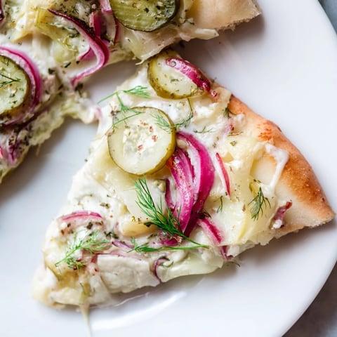 Tangy Pickle Pizza topped with creamy sauce and crunchy dill, just baked.  