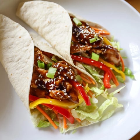 Tender teriyaki chicken wraps, filled with colorful veggies and savory sauce, ready to eat.