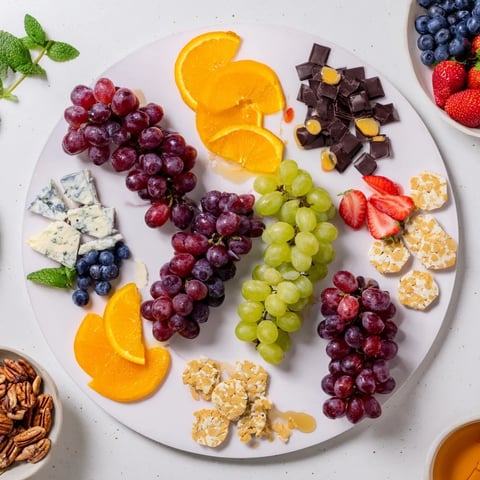 A luscious Grapes of Fortune dessert board overflowing with colorful grapes, cheeses, and treats.
