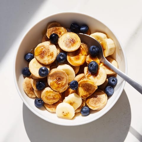 Golden-brown mini pancake cereal arranged in a bowl, ready to enjoy with milk.  