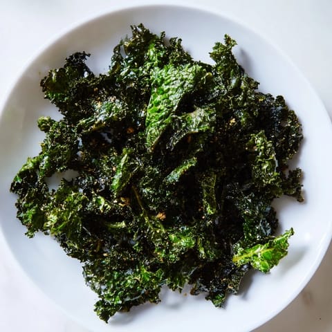 Homemade baked kale chips, fresh from the oven, offering a savory, crunchy texture.