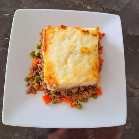 A steaming, hearty Budget Shepherds Pie, the cheesy mashed potato topping baked to perfection.