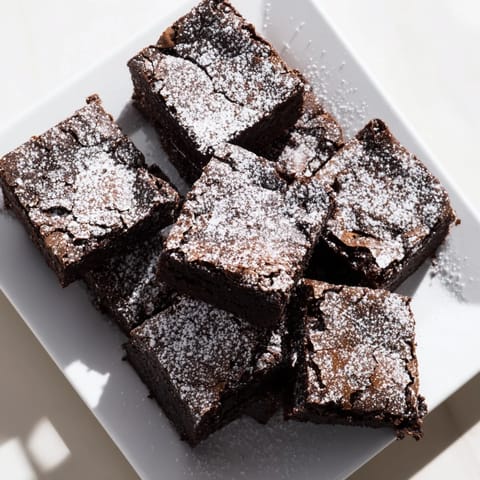 Warm, freshly baked brownie squares, the perfect treat, lightly dusted with powdered sugar.