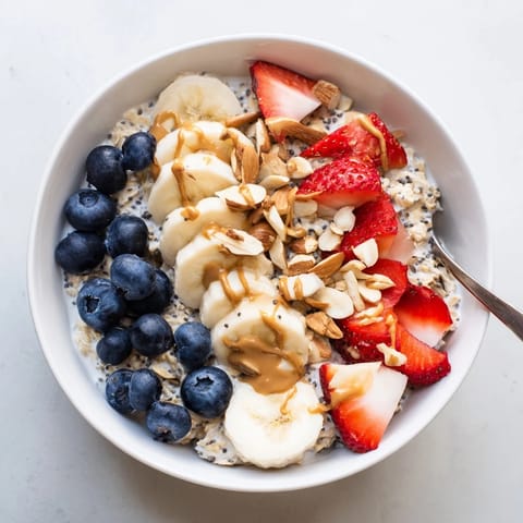 Overnight oats with chia seeds sit chilled in a glass jar, layered with creamy yogurt and topped with crunchy nuts for a nutritious breakfast.