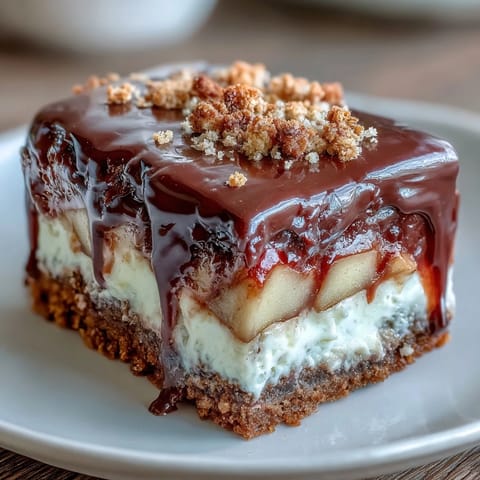 Crisp apple slices coated in rich chocolate and sprinkled with graham cracker crumbs, then drizzled with melted marshmallow for a nostalgic dessert twist.