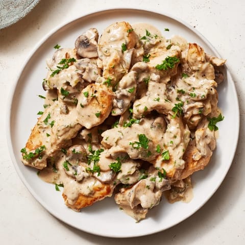 Tender Creamy Chicken Stroganoff over egg noodles, visually appealing with a rich mushroom sauce.