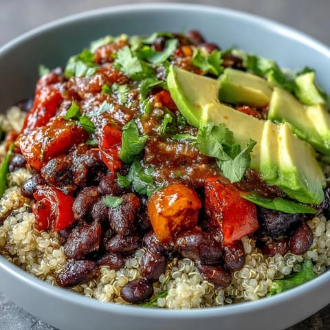 Colorful plant-based taco bowl loaded with corn, tomatoes, and creamy avocado slices.