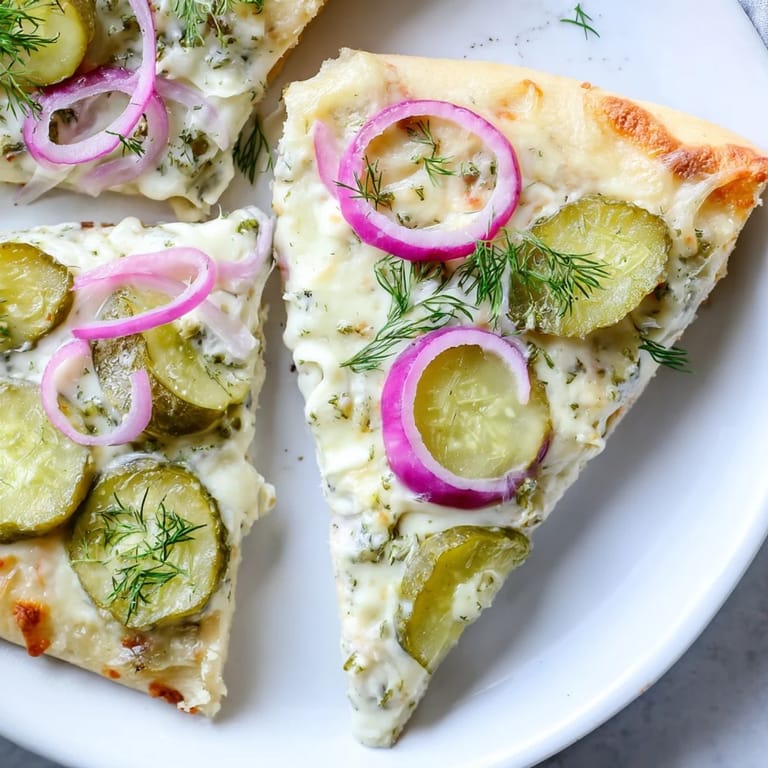Mouthwatering Pickle Pizza fresh from the oven, drizzled with crème fraîche sauce.
