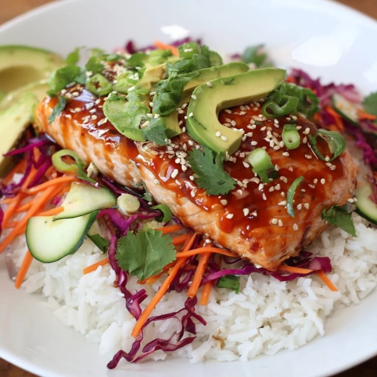 Tender baked Sweet Chili Salmon Rice Bowls, with glistening salmon and vibrant toppings, are perfect for dinner.