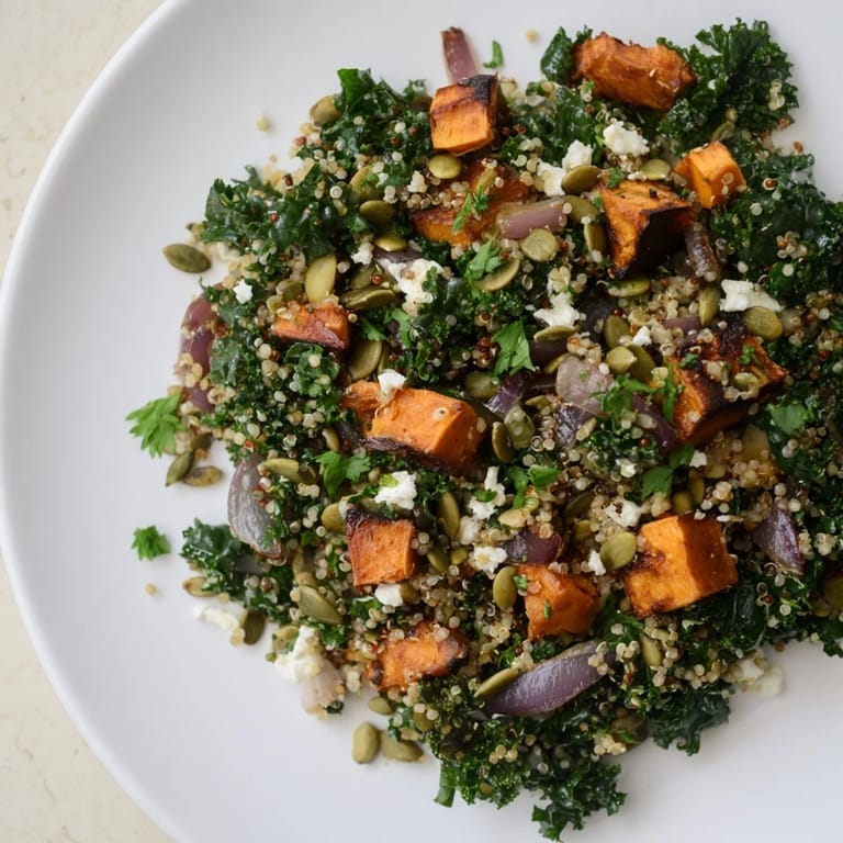 Golden roasted sweet potatoes nestled in a Kale & Quinoa Salad, drizzled with tangy dressing, ready to enjoy.